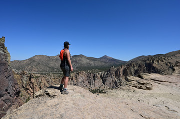 Young woman on Misery Ridge Trail in Smith Rock State Park near Terrebonne, Oregon on a coudless...