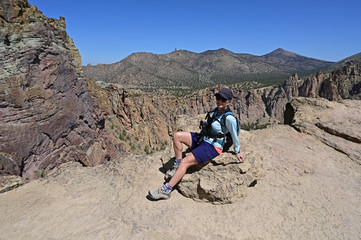Woman on Misery Ridge Trail in Smith Rock State Park near Terrebonne, Oregon on a coudless summer day.