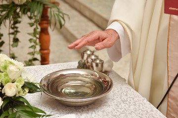 Fototapeta premium Inventory for baptism and the priest's hand in the Catholic Church.