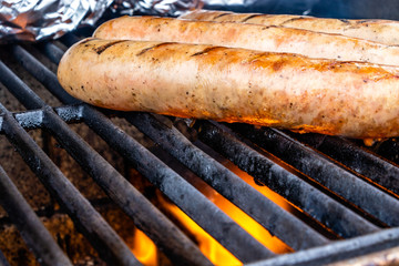 Mild Italian sauasge and baked potatoes on the grill. Calgary, Alberta, Canada
