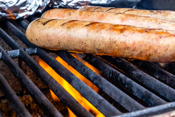 Mild Italian sauasge and baked potatoes on the grill. Calgary, Alberta, Canada