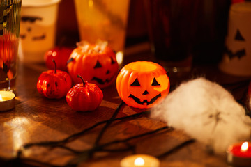 Background image of Halloween decorations, closeup of pumpkins and candles set on table for party, copy space
