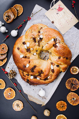 Freshly baked chrismtas  roll wreath on a wooden background with various christmas decoration