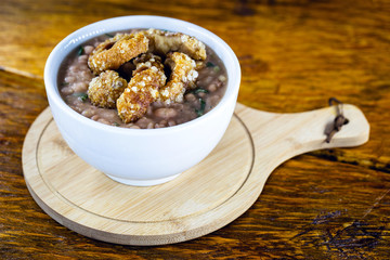 Mashed beans with sausage and pork rinds called Tutu de Feijao in Brazil. Brazilian beans with large piece of pork rinds. Typical Brazilian food. Gastronomic tourism concept.