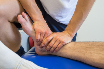 Fototapeta na wymiar Physiotherapist massaging an injured ankle