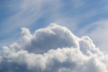 A big and fluffy cumulonimbus cloud in the blue sky background