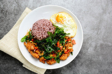 Crispy chicken cooked with green basil, served with steamed rice and fried egg, hot and spicy dish with basil leaves.
