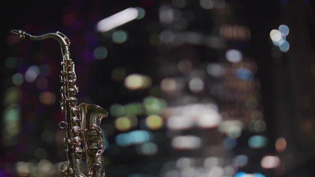 Night saxophone with beautiful bokeh from the windows of skyscrapers