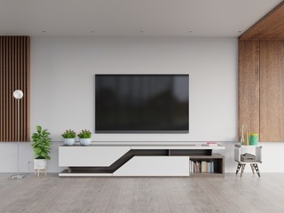 TV on the cabinet in modern living room with plants in living room with empty white wall.