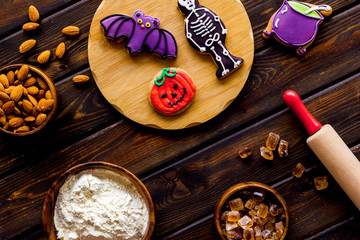Cooking creepy cookies concept with almonds, pin, flour on wooden background top view