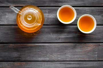Tea in pot and cups on wooden background top view mock up
