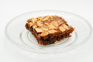 Chocolate brownie with almond topping on glass plated