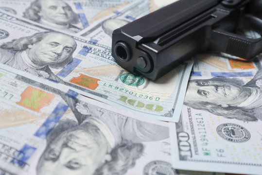 Pistol gun on 100 us dollar banknote,illegal money by gangster dirty job criminal and terrorism concept