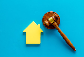 Inscribed gavel, house figure for inheritance concept on blue background top view