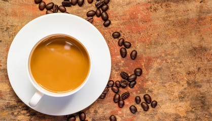 Coffee in a cup and coffee beans on the table with copy space