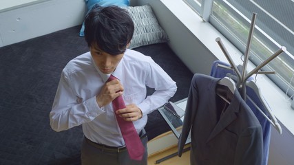 ネクタイを結ぶビジネスマン