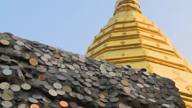 A hand held, low angle, close up shot of a roof covered with silver and copper coins.