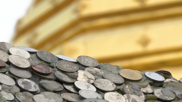 A hand held, extreme close up shot of various metal coins glued to the roof of a building.