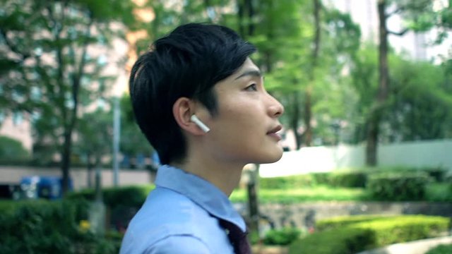 ハンズフリーで電話しながら歩く日本人ビジネスマン