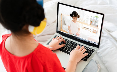 Asian girl is watching a video clip of electric piano playing on a laptop. From influencer people in online world By teaching how to play with content that is understood Cause learning, development