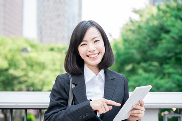 Young business woman using tablet computer outside