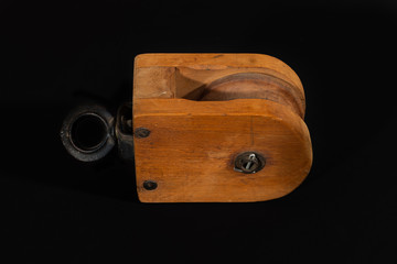 Vintage wooden pulley block isolated on a black background