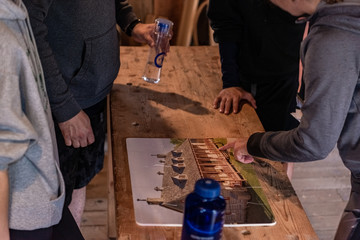 Group of creative friends playing in card game on the wool table. People enjoy a vacation together.   Card game on the wool table. Enjoy a vacation together.  Puzzle game on the table.