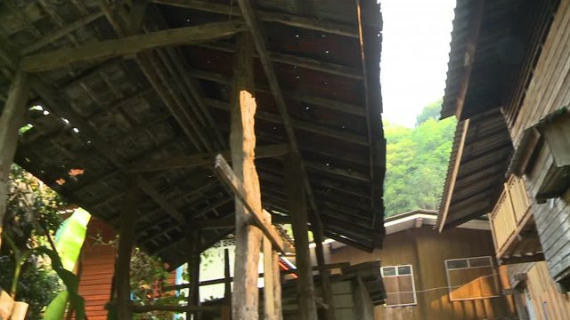 A hand held, panning, medium shot of tall homes made out of wood.