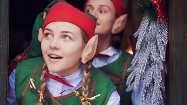 Elves opening door. Close up view of two elves opening door of Santa Claus