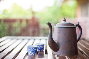 Antique Asian style tea set on a wooden table on blurred background