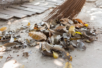 People are sweeping the leaves on the concrete floor
