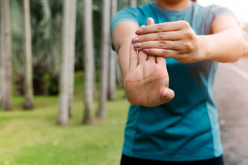sport woman stretching forearm before exercising. outdoor sport and excercise activities concept