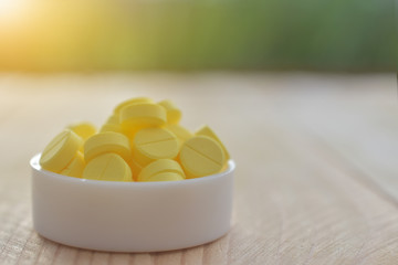 Yellow pills on wood table