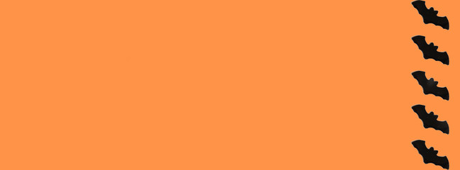 Black Paper Bats on orange background. Halloween concept. Banner for web design. Flat lay, top...