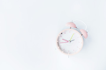 Vintage alarm clock pink color on white background. Rest hours time of life good. Flat lay, top view, copy space, mockup, overhead