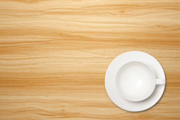 Top view of empty white coffee cup on a wood background. Template for your design.