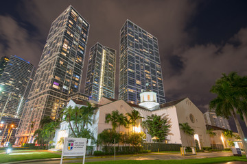 Fototapeta na wymiar Night photo First Presbyterian Church Downtown Brickell Florida USA surrounded by skyscrapers in the city. key point christian academy