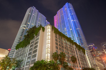 Fototapeta na wymiar Highrise architecture Miami at night. Long exposure clouds in motion and starry night sky