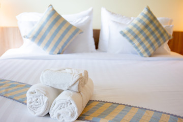 Set of white towels on the bed, towels rolled on the bed in hotel, amenity and accommodation in hotel and tourist concept.