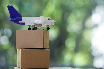 Miniature plane and cardboard box. Delivery and transportation.