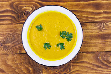 Pumpkin soup on a wooden table. Top view