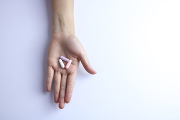 Three color capsules in the hand .