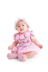 Full length of little asian baby girl in sweet pink dress sitting isolated over white background