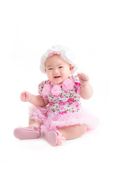 Full length of little asian baby girl in sweet pink dress sitting isolated over white background