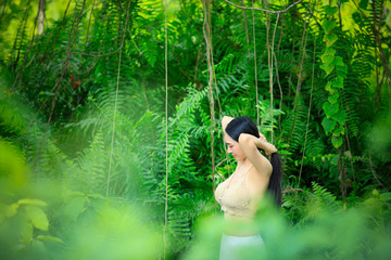 Asian sexy woman with long hair in a mysterious forest, beautiful woman with nature, vine, ferns, moss