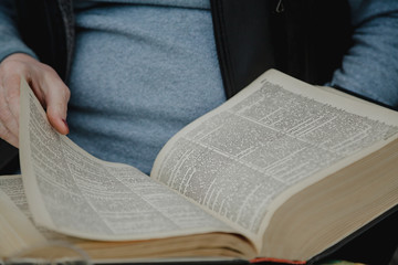 Thick book in hands of man