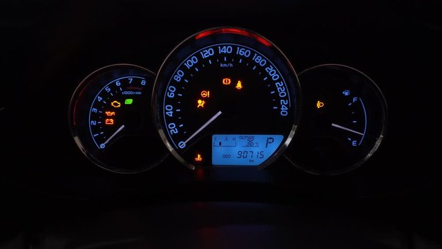 Modern car dashboard with various status symbols in night time