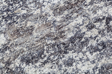 Close-up of a   gray stone wall of a very old mountains.  Gray texture background. Close-up Rock formation.