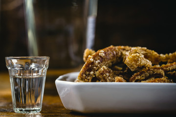 Cachaça, drops, cane or sugar cane is the name given to brandy produced in Brazil. Served with pork crackling. Typical food and drinks from Brazilian restaurants or bars.