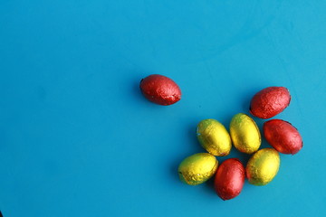 chocolate easter eggs, wrapped in yellow and red paper